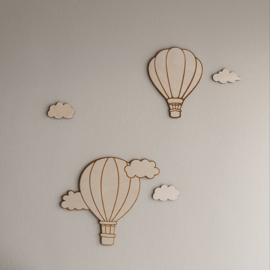 Houten muurdecoratie met gegraveerde luchtballonnen en wolkjes in babykamer van berkenhout